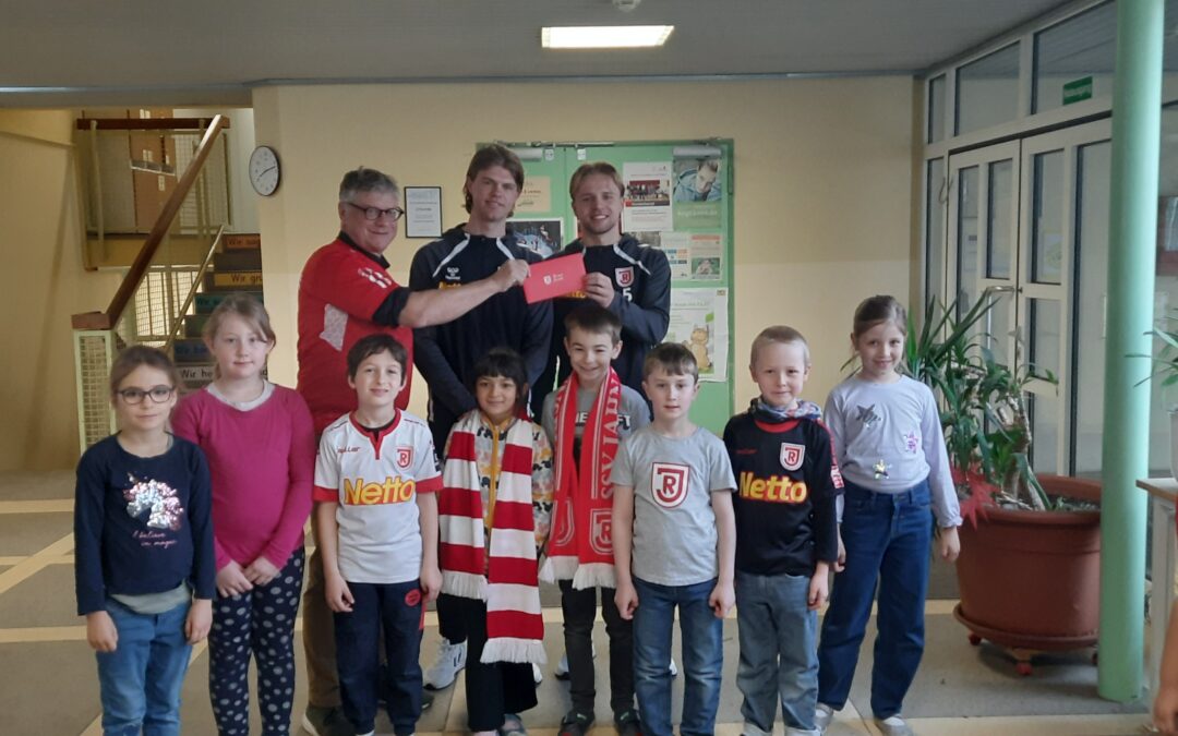 Fußball-Stars zu Gast in der Grund­schule Schwa­belweis: Ticket­übergabe durch den SSV&nbsp;Jahn